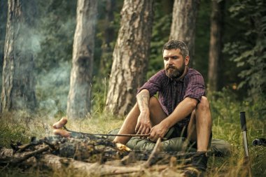 Orman bekçisi. Hipster uzun yürüyüşe çıkan kimse kızartma sosis Stick yanan orman