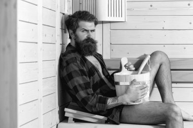 Spa uygulamaları. sakallı ciddi yakışıklı kova ile ahşap banyo