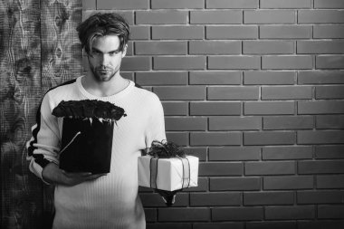 Çiçek teslim. sakallı adam tutar kırmızı gül çiçek ve hediye kutusu