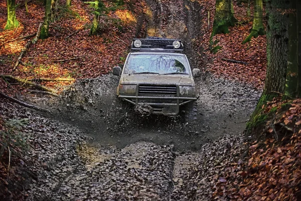 Racing på off-road bilar. SUV täckt med lera som fastnat i smuts på väg — Stockfoto