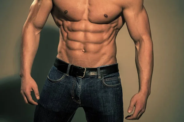 Männerpresse. athletischer Bodybuilder Mann auf grauem Hintergrund. — Stockfoto