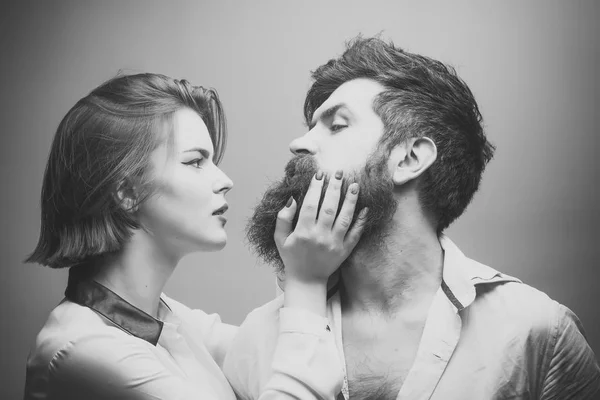 Parejas enamoradas. Peluquería mujer haciendo forma de barba, toques. Hombre con barba larga, bigote y pelo elegante, fondo claro. Chico con peinado moderno visitó peluquería. Barbería o —  Fotos de Stock