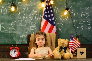 Yetenekli çocuk genellikle koçluk ihtiyacı var. ABD'de İngilizce dil öğrenme. Eğitim İngilizce. Üniversite öğrencileri kitaplığında karşı masada ABD bayrağı yukarı başparmak el hareketi