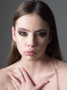 Makyaj modeli yumuşak deri ile dumanlı gözler. Moda bakmak kavramı. Son moda ve kadın ile şık saç moda makyaj. Gri arka plan üzerinde soluk yüz kızla. Güzellik ve Kuaför.