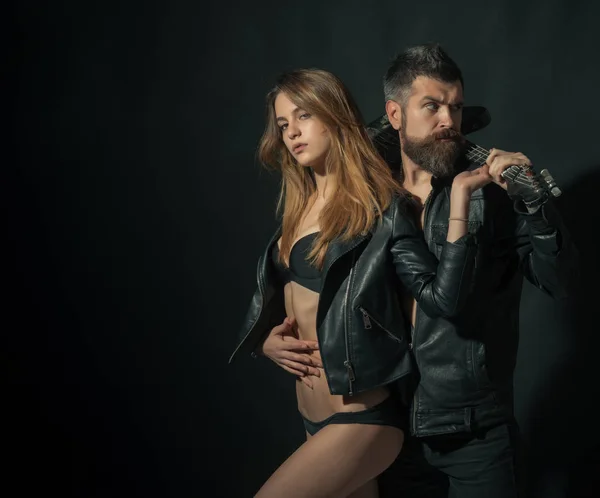 Cuplu îndrăgostit îmbrăţişându-se cu chitară, fundal negru. Rock and roll concept. Cuplu sexy si brutal pozand cu chitara. Chitarist cu barbă și fată sexy în sutien se bucură de stilul de viață rock and roll — Fotografie, imagine de stoc