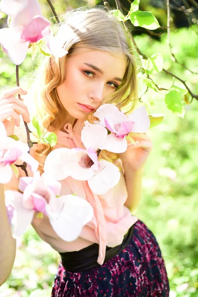 De vrouw van de lente in bloei van de bloem. Magnolia bloem schoonheid in de natuur. Huidverzorging en zomer concept. Womens dag met meisje in roze bloesem. Sensuele vrouw op bloeiende magnolia bloem in het voorjaar — Stockfoto