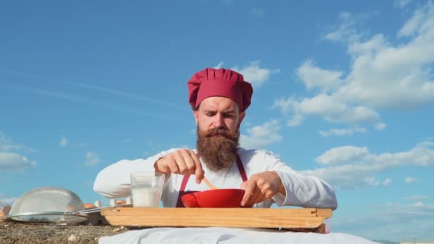 Baker s řadou zdravých a chutných čerstvě upečený chléb a pečivo. Usměvavý muž baker nalévat mouky. Veselý mladý Pekař. Baker ruce hnětení těsto v mouce na stole. — Stock video