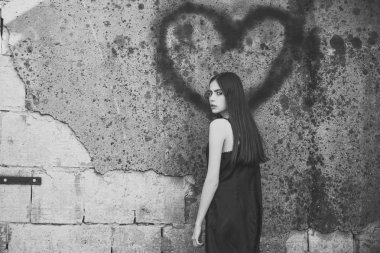 tek taraflı aşk. Gri duvar grafiti kalp ile poz kadın