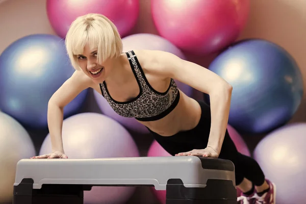 Tägliche Fitness. Mädchen im Sportkleidungstraining auf Trittplattform im Fitnessstudio. — Stockfoto