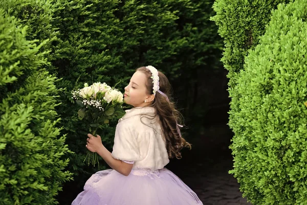 Ragazza con i fiori. Ragazza bambino nel parco verde estivo, primavera . — Foto Stock