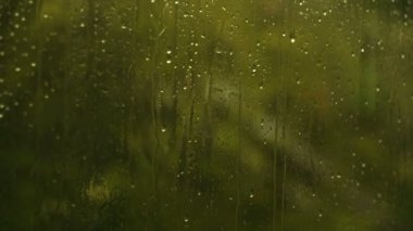 Yeşil parıltı penceresindeki su damlaları