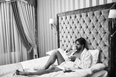 Otelde Süiti. sakallı adam yatakta kahve ile