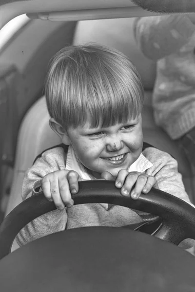 A criança está a conduzir. Bonito menino finge dirigir carro — Fotografia de Stock