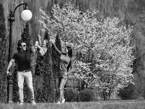 家族の休日。咲く公園で幸せな家族 — ストック写真