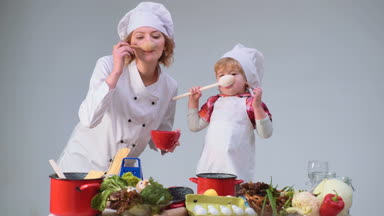 Sevimli küçük çocuk ve mutfakta yemek yaparken gülümseyen güzel annesi. Genç aile yemek yemek mutfakta. Genç Anne ve oğlu birlikte yemek yemek. Çocuk çocukluk çocuklar mutluluk kavramı.