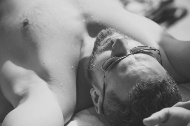 adam güneş banyosu. Sakallı yüzü güneş banyosu olan çocukla.