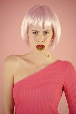 samimi oyuncaklar. Kız yapay saç tutun kırmızı dut ağzına.