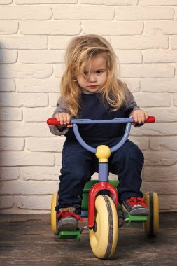 Çocuk odasında bisiklet sürme. Çocuk ve üç tekerlekli bisiklet