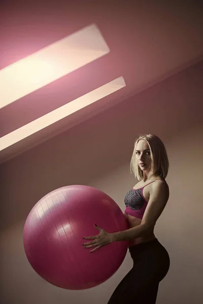Exercises for women with the ball. Girl athlete in sportswear with pink fitball — Stock Photo, Image