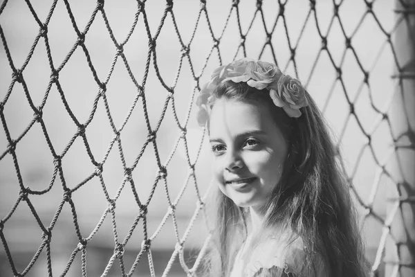 Jarní módní vzhled. Malá holčička s květinou ve vlasech na net, dětství a štěstí. Kadeřnice a účes. — Stock fotografie