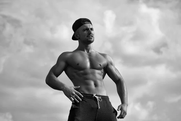 Ćwiczenia sportowe dla mężczyzn. Sexy man mięśni na tle nieba — Zdjęcie stockowe