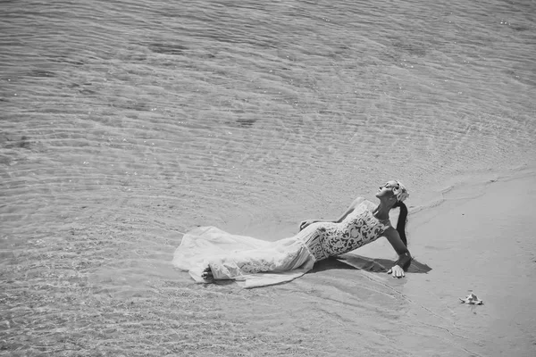 Balayı gezisi. Deniz sahilde yatan kadın — Stok fotoğraf