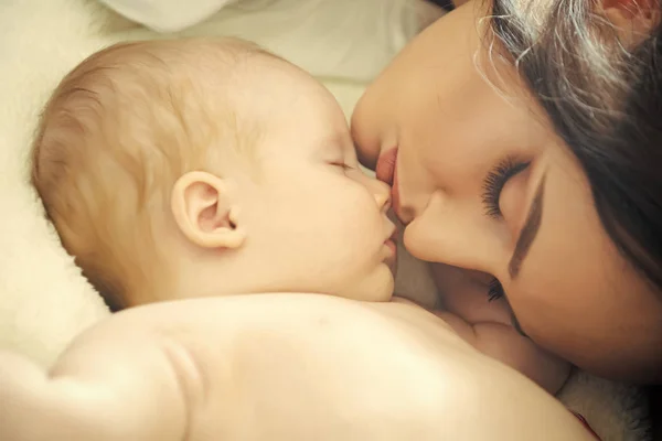 Maternidade. Mãe e bebê dormem na cama — Fotografia de Stock