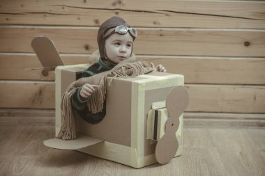 bir karton kutunun içinde uçan çocuk pilot