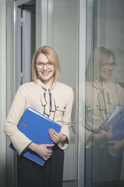 Seksi Sekreter gülümseme belgeleri ile. İş kadını ile iş kağıtları. Mutlu kadın ofiste dosya klasörü tutun. Evrak ve bürokrasi kavramı. Yoğun bir gün ofiste