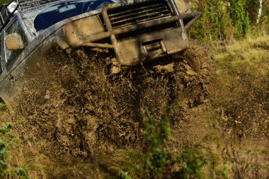 SUV yarış Sonbahar Doğa arka plan üzerinde yer alır. Otomobil Yarış, araba yıkama ve off road araç konsepti araba ile güçlü şasi ve tekerlek aks üstesinden engeller