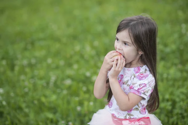 Menina bonita comendo maçã vermelha — Fotografia de Stock