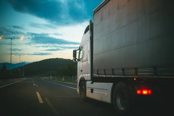 Conduce en camión por la carretera por la noche. Carga de transporte de camiones. Transporte y envío. Concepto de velocidad y entrega. Viajes o viajes y ansia de viajar —  Fotos de Stock