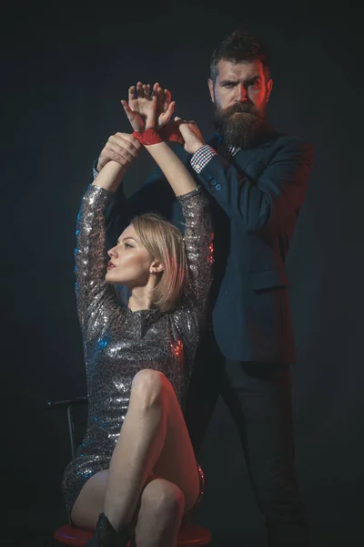 Hoe zich te gedragen op kantoor kerstfeest. Paar spelen spel met gebonden dame. Beschamende openbare gedrag. Man met baard en vrouw kantoorpersoneel vieren vakantie. Vrouw fettered door ethiek — Stockfoto