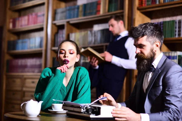 Par i biblioteket med skrivmaskin och tekanna dricka kaffe från cup. litteratur café med skäggig man och söt tjej. studentlivet i universitet. Agile business och grammatik koncept. datum eller möte. — Stockfoto