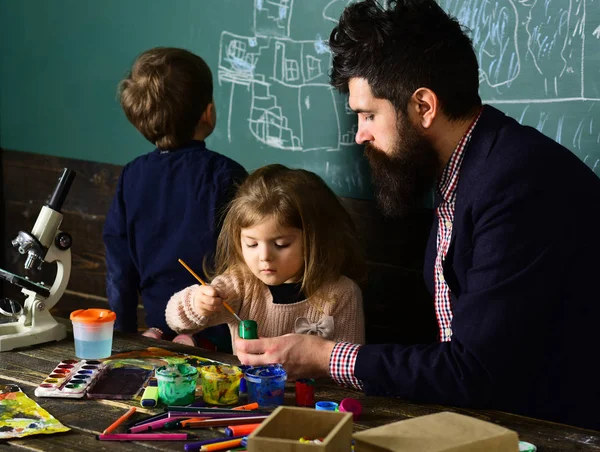 Unterricht mit qualifiziertem Privatlehrer. Kinder tun sich schwer, wenn sie Hausaufgaben machen, also brauchen sie Nachhilfe. Lehrerin hilft Schülerin im Klassenzimmer der Grundschule — Stockfoto