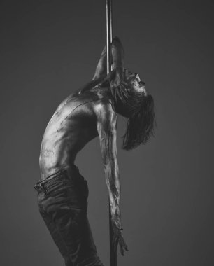 Pilon üzerinde dans dersleri. Adam çıplak gövde kaplı parıltı ter veya boya ile