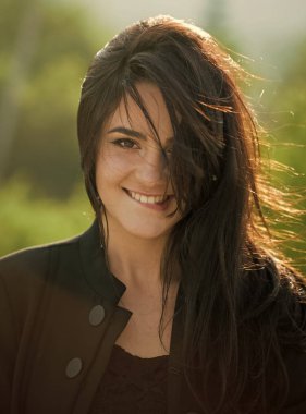 yavaşça dudaklarını ısırdı. Sıcak seksi kadın. Güneşli bir gün uzun esmer saçlı kadın mutlu gülümseme