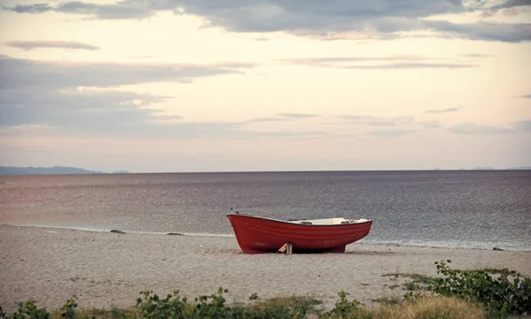 Bateau sur la plage. Bateau de pêcheurs au bord de la mer, sur le sable par temps nuageux avec mer en arrière-plan. Bateau de pêche sur la plage en soirée. Concept de voyage et de repos. Fond de la mer avec des vagues et le ciel avec — Photo