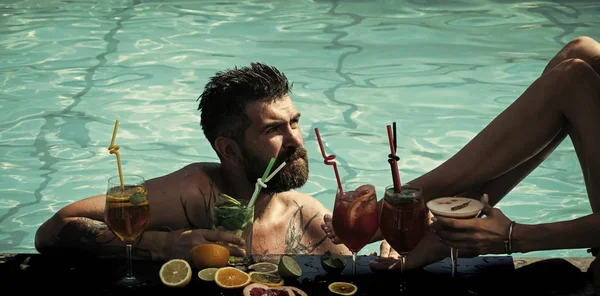 Partij bij het zwembad. Cocktail en bebaarde man in zwembad. — Stockfoto