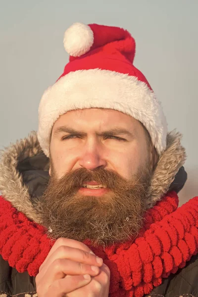 Babbo Natale in cappello rosso e sciarpa. Ragazzo di anno nuovo su cielo blu . — Foto Stock