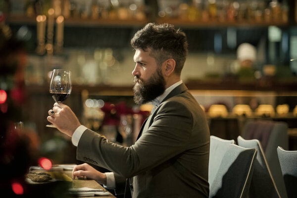 man is tasting the wine. Romantic dinner. young man standing and holding wineglasses.