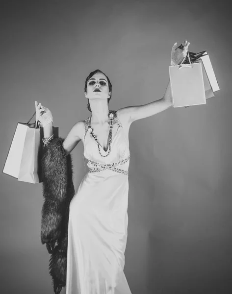 Belleza y moda vintage. Chica en vestido amarillo, boa con bolsa o paquete de regalo . —  Fotos de Stock