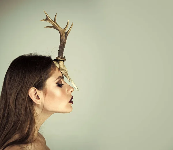 Creative fashion photography. Woman with makeup and antlers. Fashion devil of mystic shaman girl with horns. Beauty look and cosmetics for skincare. Dark fantasy creature elf on halloween in skull — Stock Photo, Image
