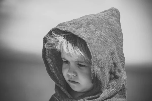 Trauriges Kind in einer Kapuze. kleiner Junge oder Kind in blauer Frottee-Kapuze sonniger Sommer — Stockfoto