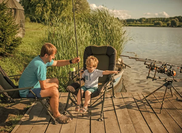 Padre con suo figlio in una battuta di pesca. Padre con figlio impegnato nella pesca nel fiume — Foto Stock