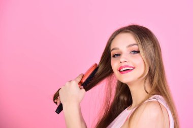 Manken güzel saçları fırça. Saç fırçası pembe bir arka plan üzerinde olan kız. Seksi kadın tarak uzun düz saç. Saç bakım ve güzellik. Mükemmel Kuaför. Kuaför ve güzellik salonu.