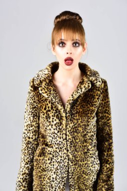 Doğal ve suni malzeme ile kürk ceket butik. Moda model bir baş ağrısı ile görünümünü. Kış moda ve güzellik. Leopar kürk ceket gri arka plan üzerinde kadın. Leopar kürkü şık kız.