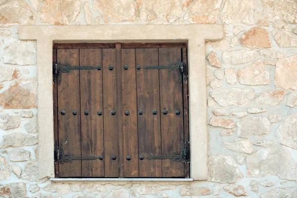 Window shutters on old stone wall. Building facade wall with wooden shutters closed. Architecture structure and design — Stock Photo, Image