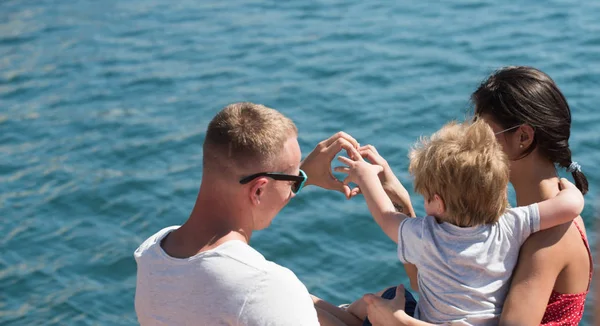 快乐家庭的暑假。暑假与母亲的父亲和儿子在海上形成心脏从手. — 图库照片
