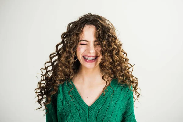 Chica con el pelo rizado en la peluquería en la pared blanca. Chica parisina con ropa de invierno. Aspecto de moda y concepto de belleza. Mujer de moda en jersey verde. Chica retro con maquillaje elegante y cabello en París —  Fotos de Stock